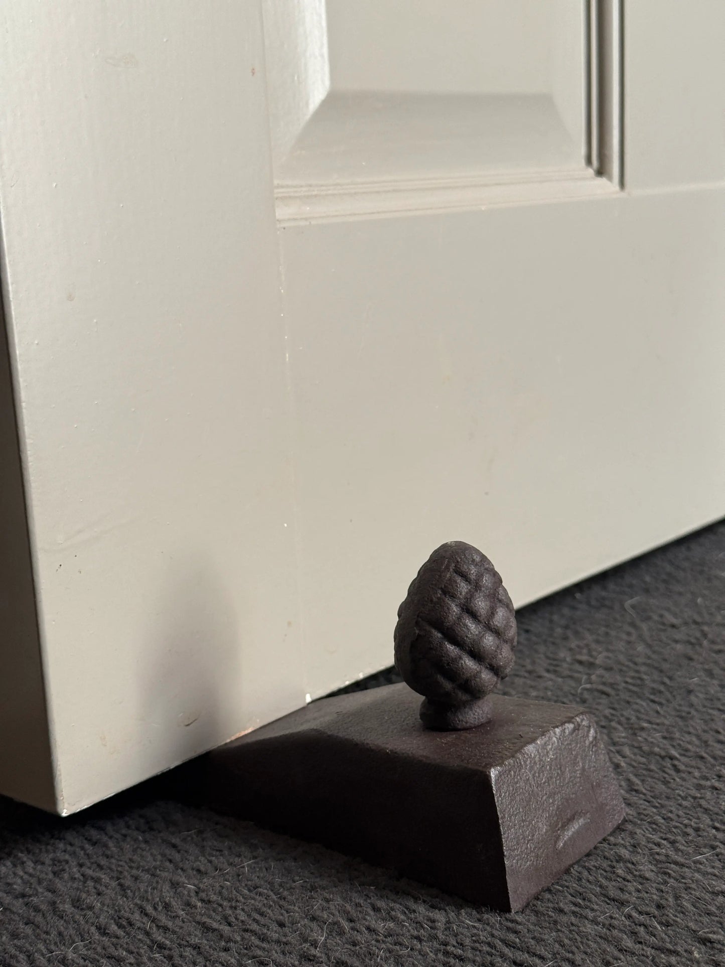 Smeedijzeren deurstopper met dennenappel