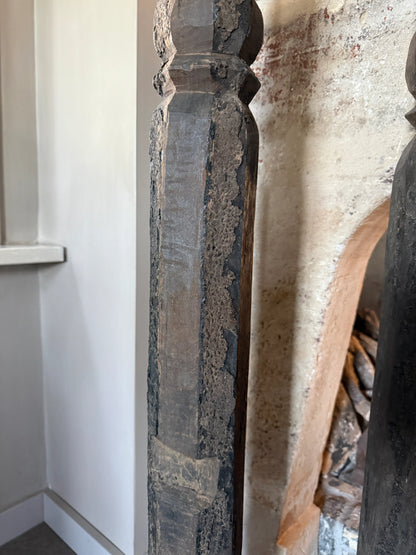 Oude hoge baluster kandelaar op metalen voet, linker op de afbeelding