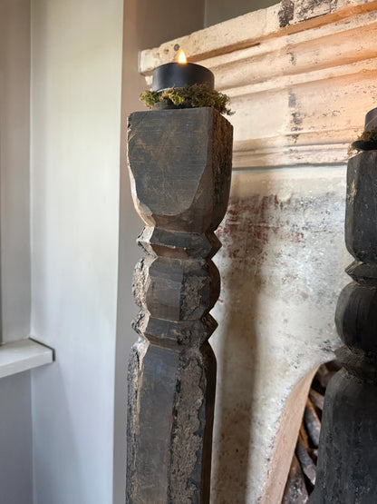 Oude hoge baluster kandelaar op metalen voet, linker op de afbeelding